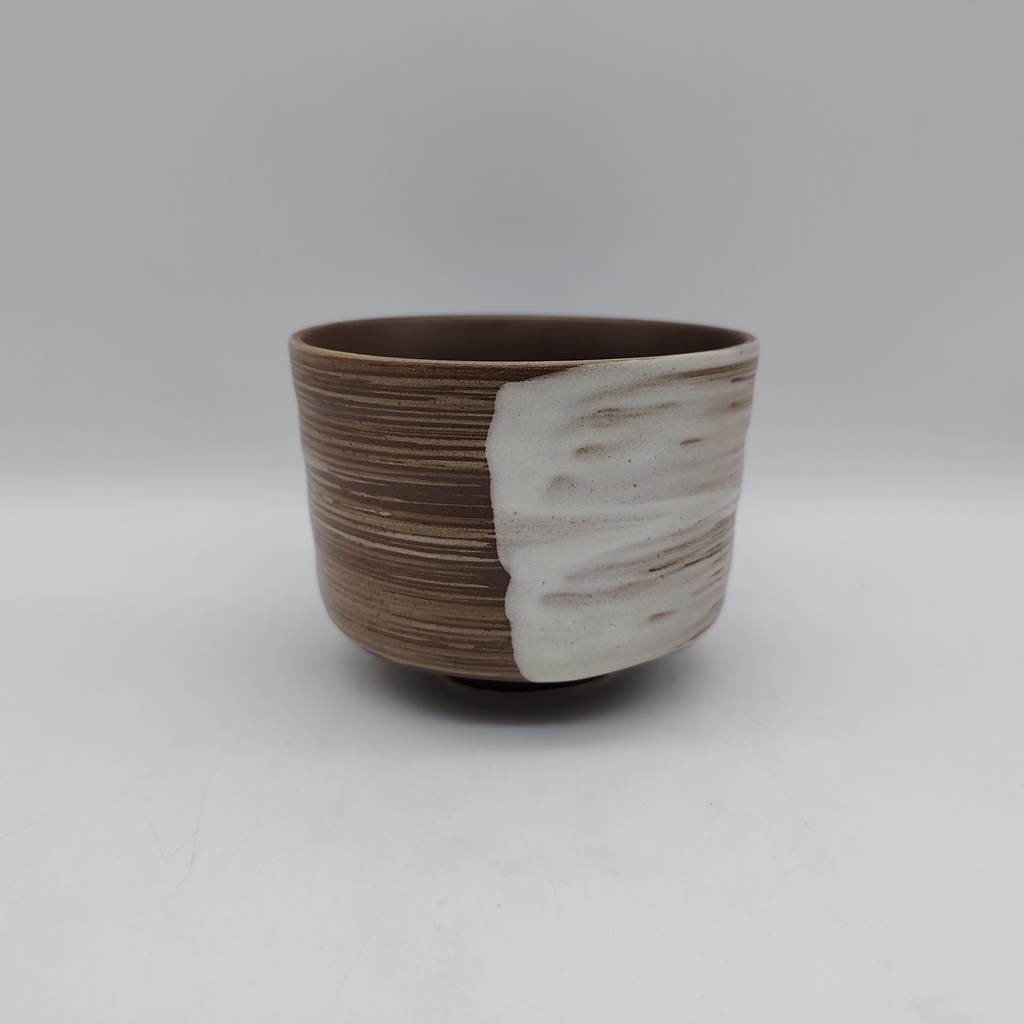Tazza per il tè matcha artigianale "chawan", realizzata in ceramica color terra decorata con una pennellata bianca.