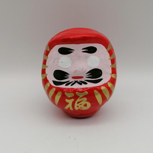 Bambola Daruma rossa tradizionale giapponese, vista frontale con dettagli del volto stilizzato