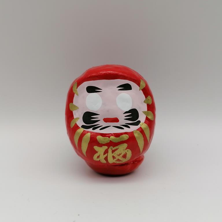 Bambola Daruma rossa tradizionale giapponese, vista frontale con dettagli del volto stilizzato