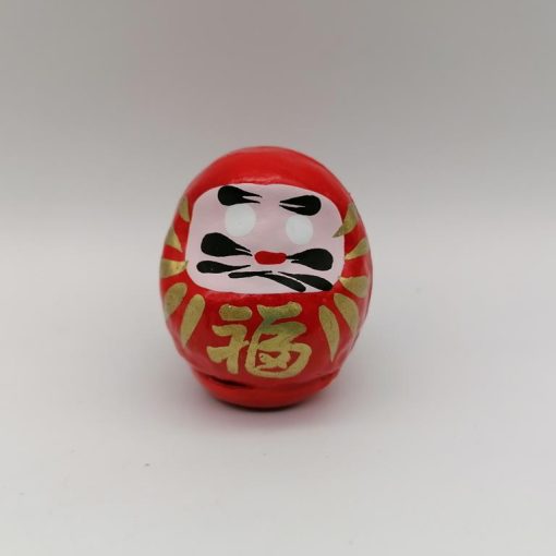 Bambola Daruma rossa tradizionale giapponese, vista frontale con dettagli del volto stilizzato